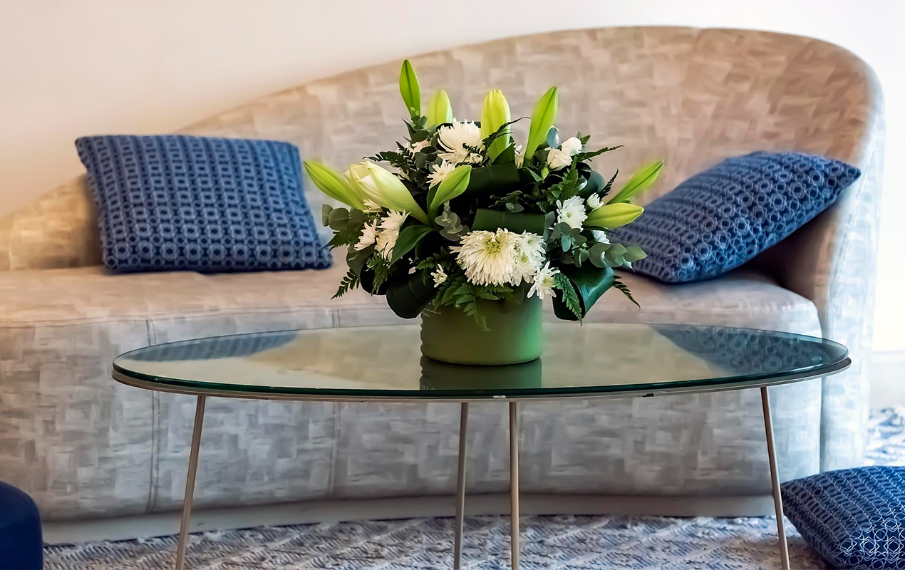 Living room interior with oval coffee table and floral display