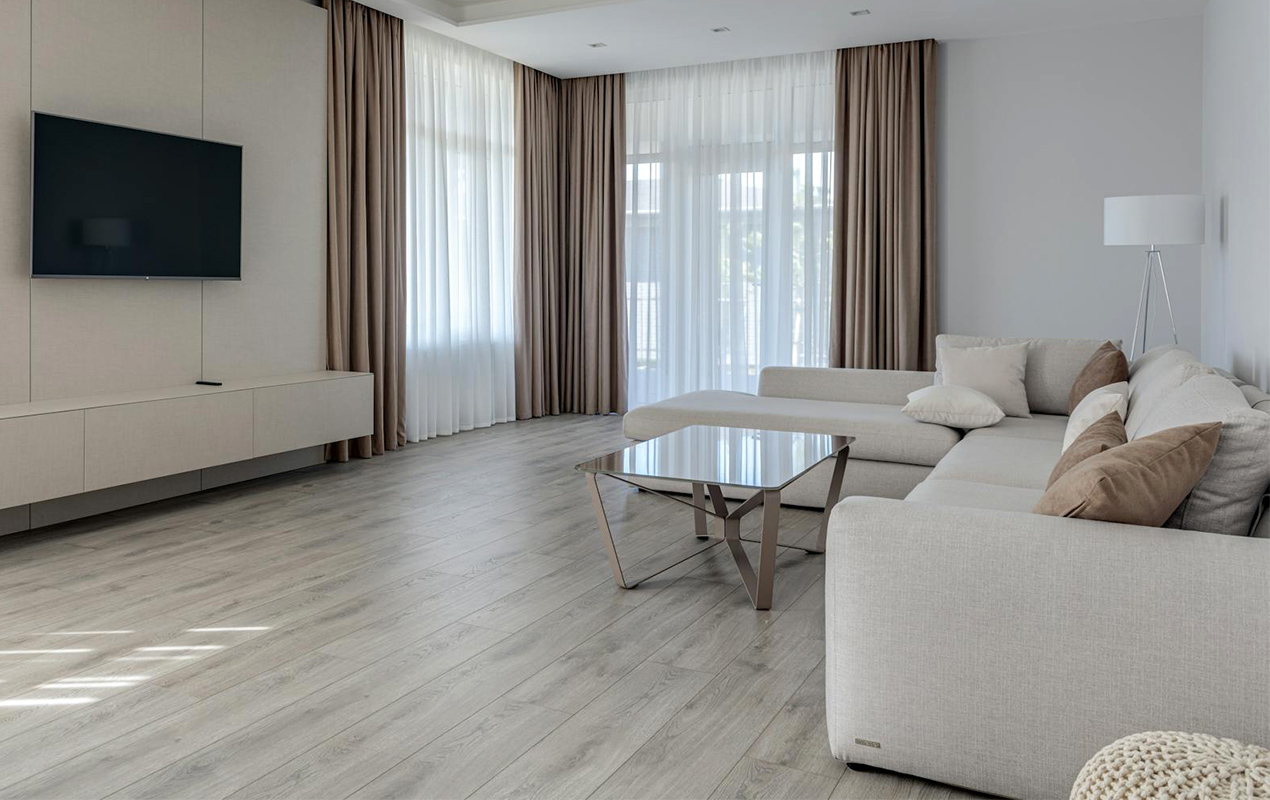 Home interior with gray wooden floor and high curtains